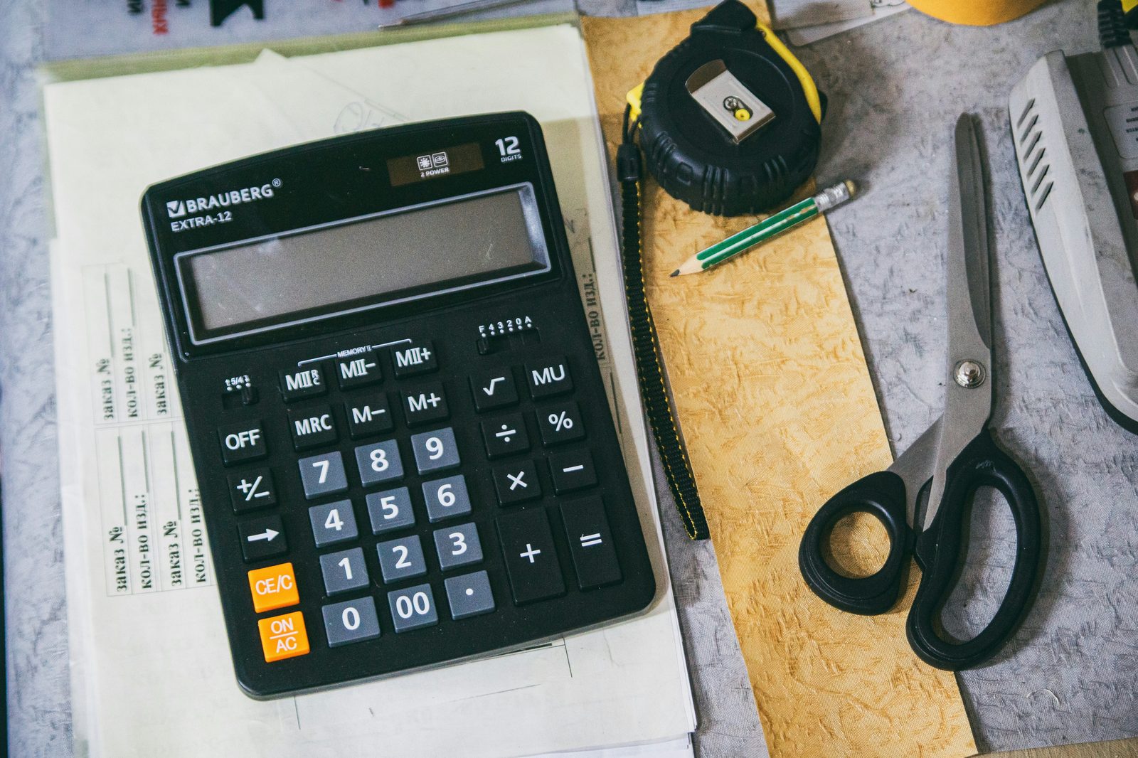 Calculator and office supplies on a desk for bookkeeping